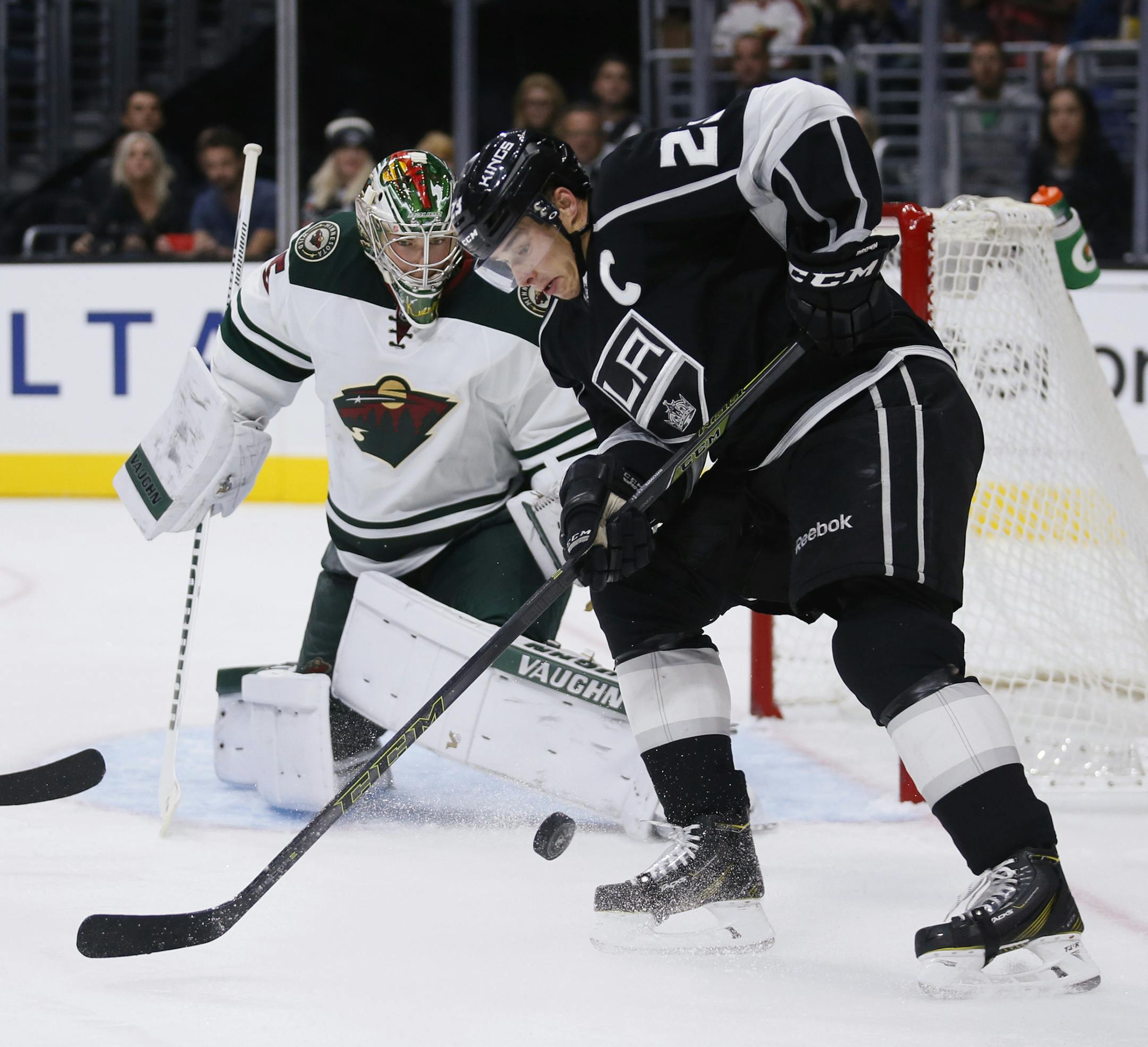 Minnesota Wild goalie Darcy Kuemper, left, looks to prevent Los Angeles Kings right wing Dustin Brown, right, from scoring during the second period of an NHL hockey game, Friday, Oct. 16, 2015, in Los Angeles. (AP Photo/Danny Moloshok)