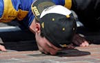 Alexander Rossi kisses the bricks on the start/finish line after wining the 100th running of the Indianapolis 500 auto race at Indianapolis Motor Spee