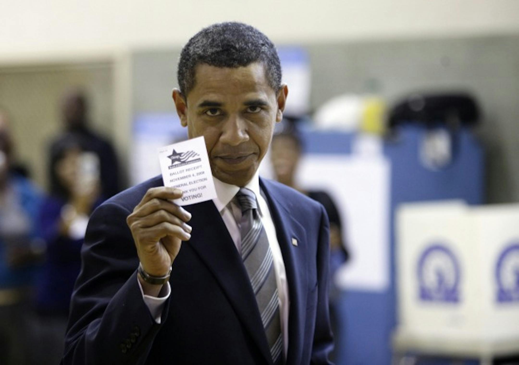 In this 2008 file photo, then Sen. Barack Obama holds up his voting card after voting in Chicago.
