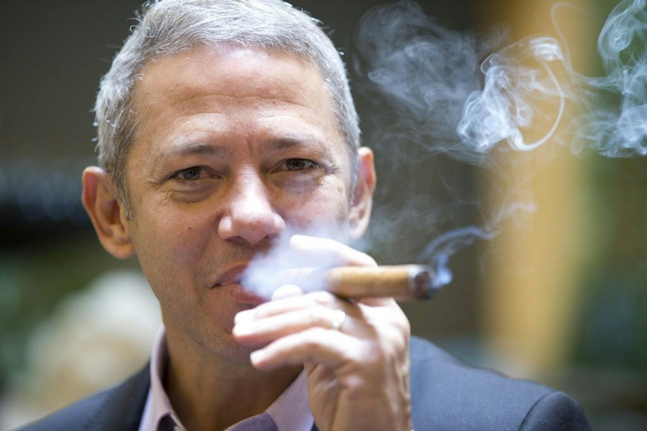 In this Thursday, Dec. 18, 2014 photo, Roberto Ramos, president of the Cubaocho Art and Research Center in Miami�s Little Havana neighborhood, smokes a cigar in the court yard of the center.