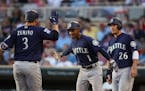 Seattle's Jarrod Dyson (1) and Danny Valencia (26) greeted teammate Mike Zunino at home after his three run homer in the third inning put the Mariners