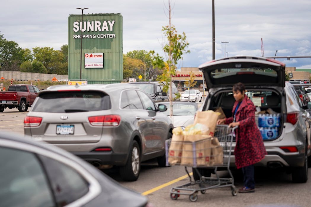 A Cub Foods shopper loads her car as the Sun Ray Shopping Center's sign looms over its parking lot on in St. Paul, Minn., on Wednesday, Oct. 4, 2023. The sign was repainted later in the year.