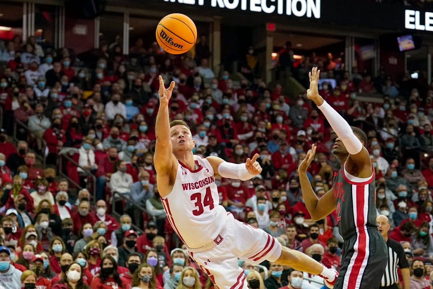 Wisconsin's Brad Davison (34) shoots against Ohio State's Malaki Branham (22) during the second half of an NCAA college basketball game Thursday, Jan. 13, 2022, in Madison, Wis. Wisconsin won 78-68. (AP Photo/Andy Manis)