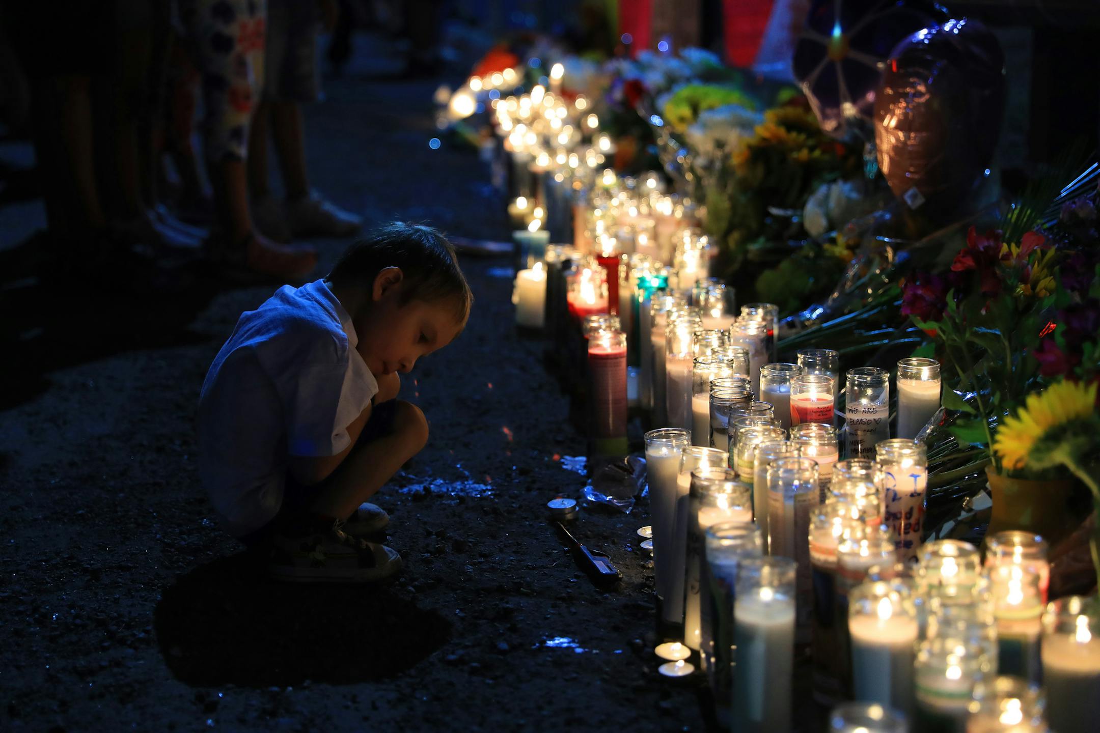 A young boy at a candlelight vigil in El Paso, Texas, on Sunday night, Aug. 4, 2019, one day after a gunman opened fire inside a Walmart, killing 20 and wounding more than two dozen others. As the city moved fitfully through its first day after the shooting, many residents said they condemned the hateful and racist message spewed by the gunman in a manifesto that railed against immigration and a “Hispanic invasion of Texas.” (Jim Wilson/The New York Times)