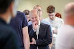 German Chancellor Olaf Scholz waits in line to cast his vote for the European Parliament elections, in Potsdam, Germany, Sunday, June 9, 2024.