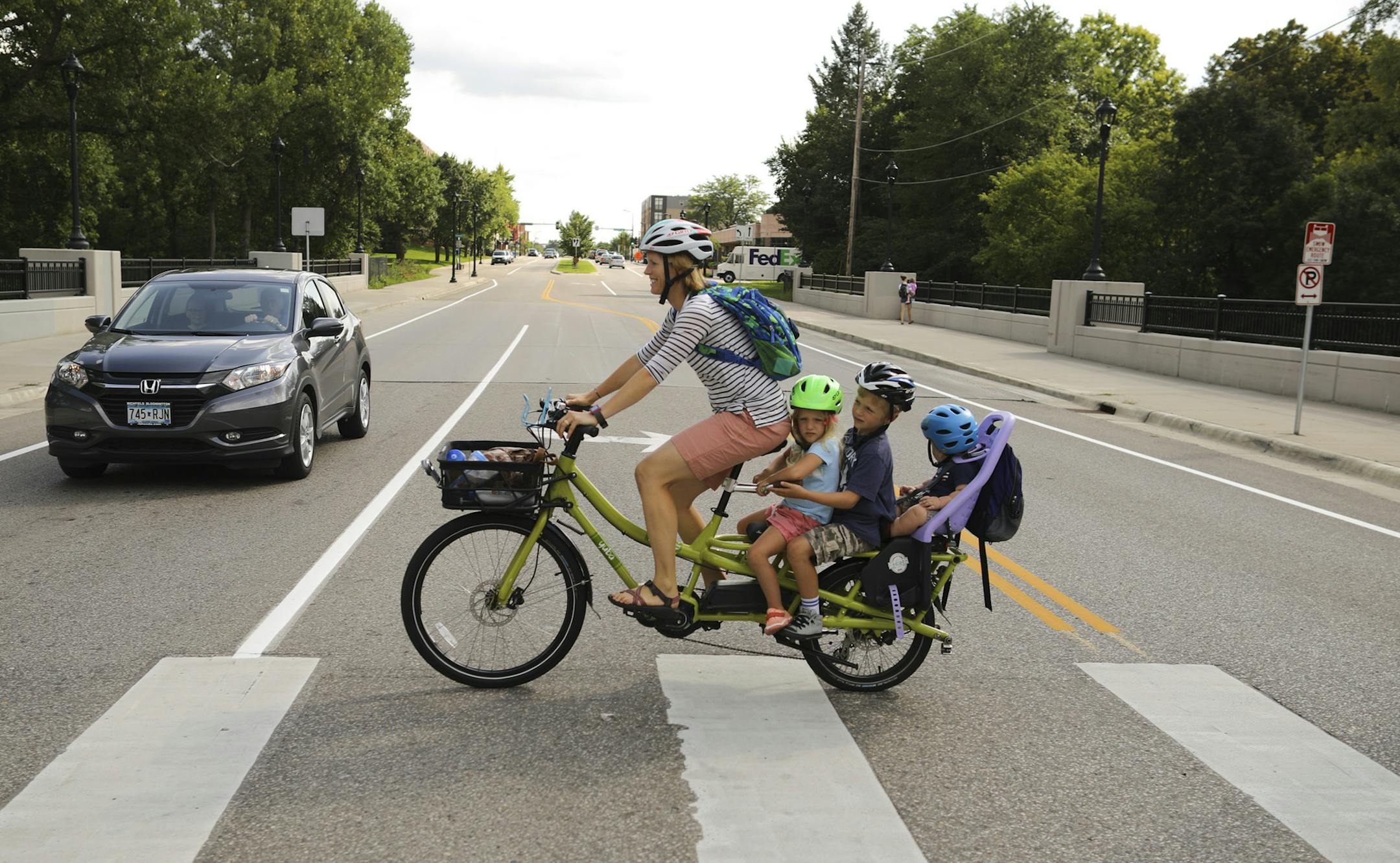 Stephanie Brodegard crossed Lyndale Ave. S. as she biked home from her son's school with all three of their kids seated on the back rack of her cargo bike. The kids are, front to back, Darcy, 4, Grant, 6, and Lewis, 1.