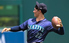 Seattle Mariners pitcher Bryan Woo throws a football as part of his warm up routine before his start of a baseball game against the Washington Nationa
