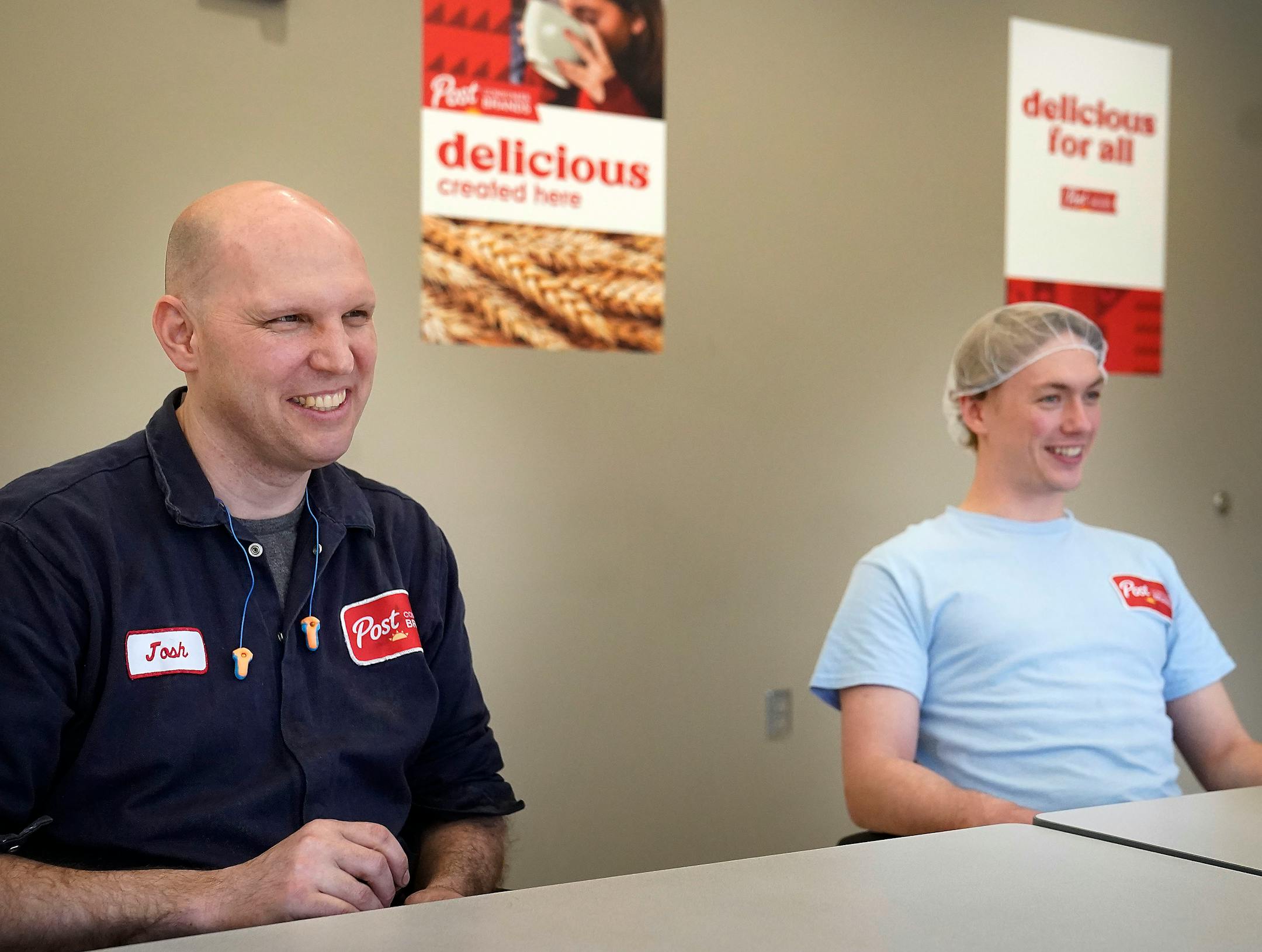 Post employees Josh Opatrny and Noah Moyer seated at table.