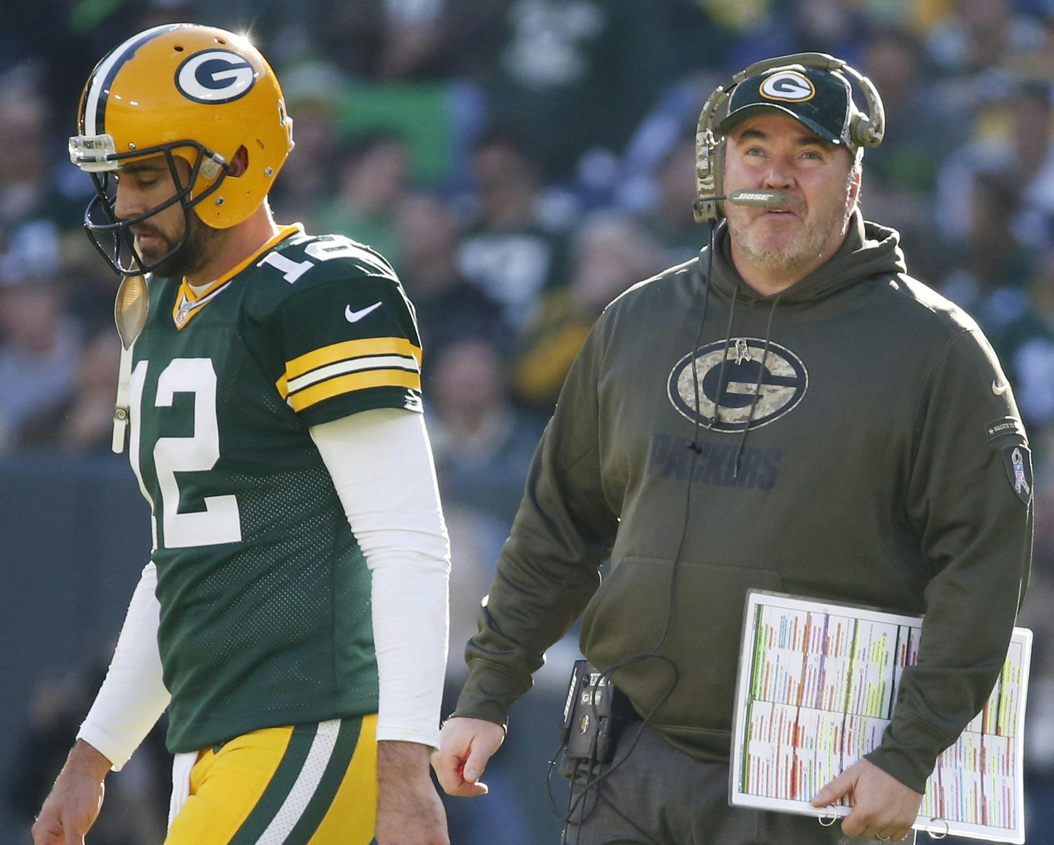 Packers coach Mike McCarthy talked to quarterback Aaron Rodgers during the first half against the Lions on Sunday.
