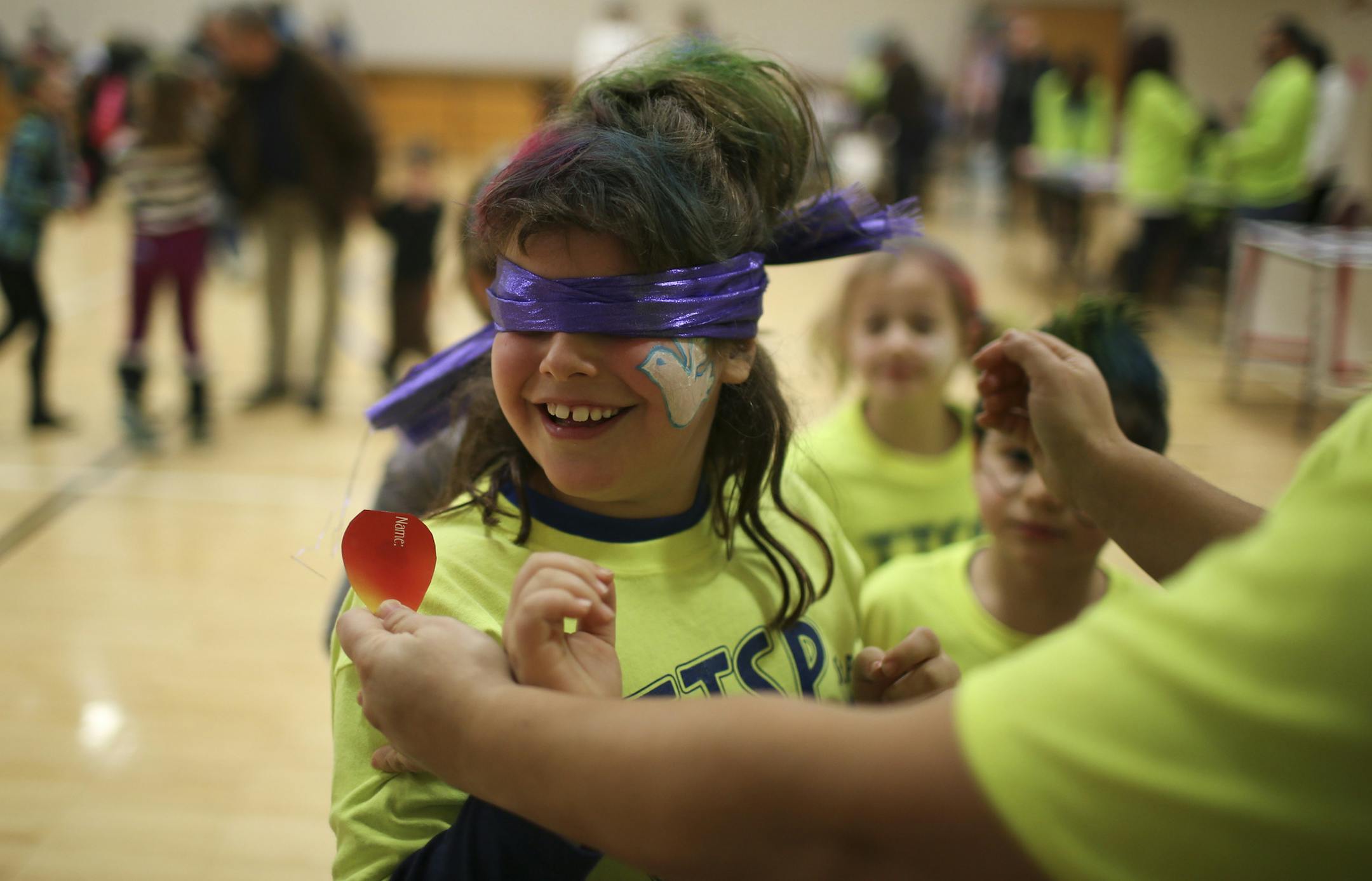 Zoe Glaseer, 8, was spun around after being blindfolded during a game of "Pin the flame on the Hanukiah."