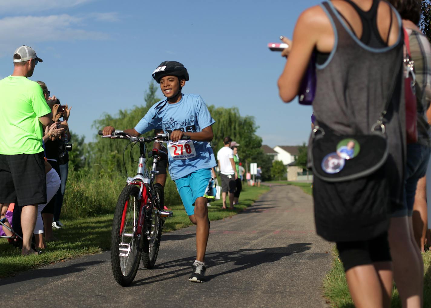 Christian Champion,11, walks his bike through the end of the cycling portion of the Kid's Triathlon on Saturday morning. ] Blaine hosted their first Kid's Triathlon on Saturday morning at Lakeside Commons Park. The competitors completed a 165 yard swim, 2.3 mile bike ride, and 1 mile run. MONICA HERNDON monica.herndon@startribune.com Blaine MN 07/26/14