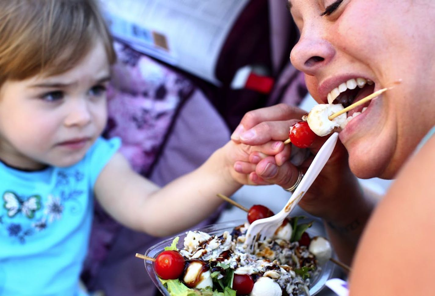 Though Gabby Bach, a 2-year-old from Ramsey, didn't want to try the Salad on a Stick, she helpfully fed a helping to her mother, Andrea Bach.