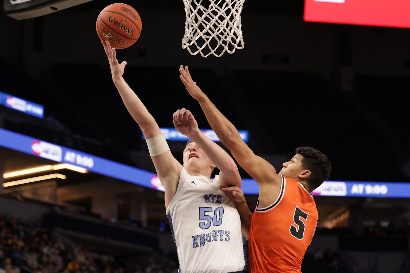 Russell-Tyler-Ruthton's Drew Werkman (50) lays the ball up beyond the reach of Noah Asuma (5). Werkman finished with 16 points in the Knights' 61-57 seminfinal win. Photo by Cheryl A. Myers, SportsEngine