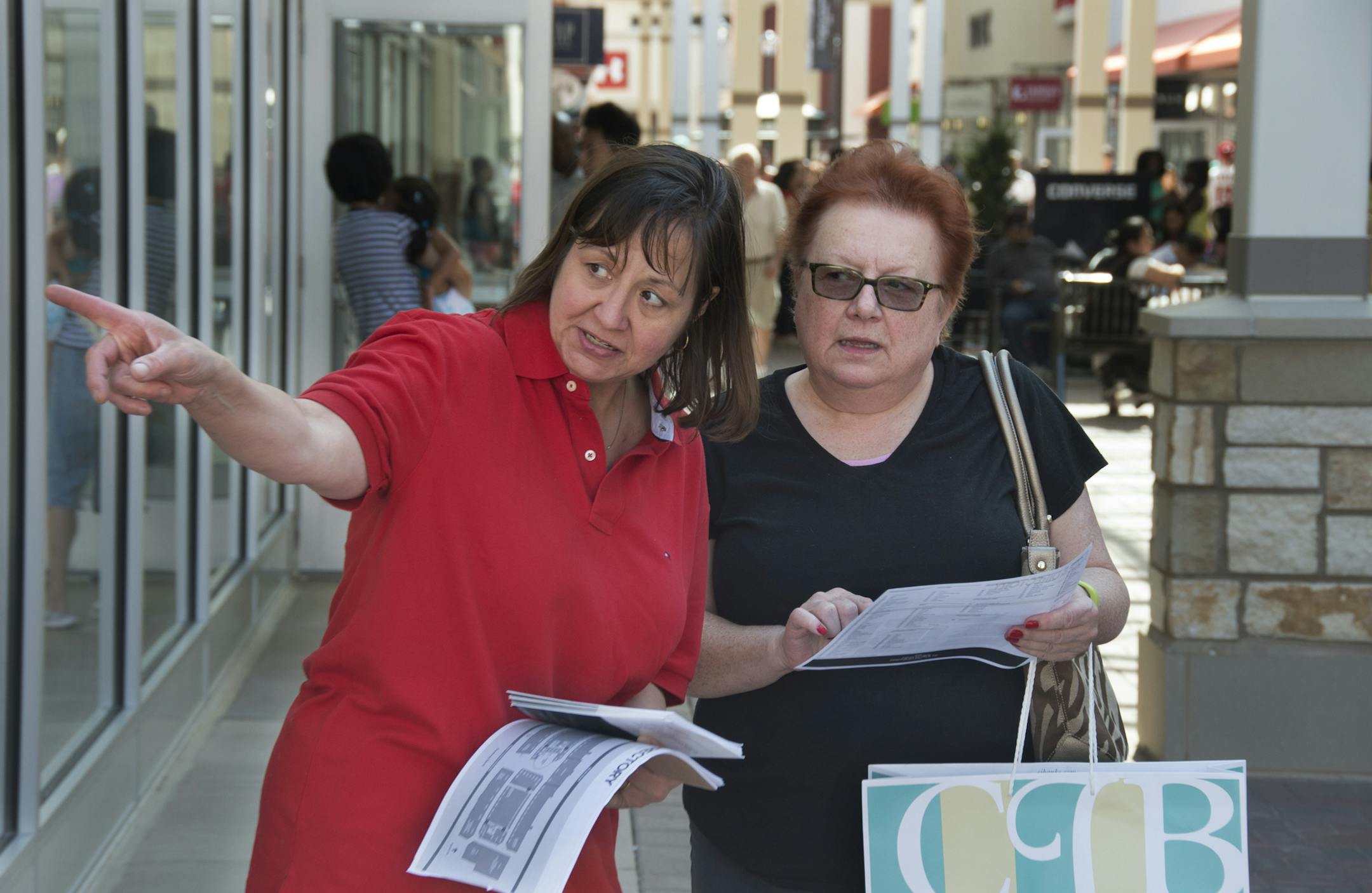 Cathy Moore, a greeter at the mall, helped shopper Mary Devine, from Eagan, with directions and a map of the Twin Cities Permium Outlets. ] The first Twin Cities outlet mall to be placed in a first ring suburb instead of an exurb opens today (Thurs) in Eagan. 123301 Outlets 20035776C (DAVID BREWSTER/STAR TRIBUNE)