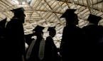 Dressed in their cap and gowns, Yelm High School seniors are silhouetted against the ceiling of the Tacoma Dome in Tacoma, Wash. during commencement e
