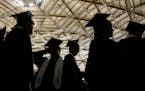 Dressed in their cap and gowns, Yelm High School seniors are silhouetted against the ceiling of the Tacoma Dome in Tacoma, Wash. during commencement e