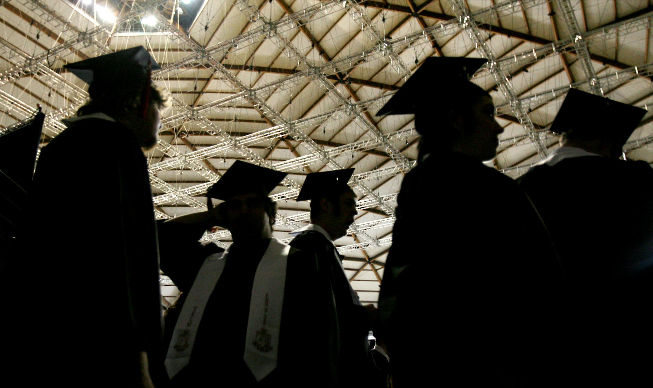 Dressed in their cap and gowns, Yelm High School seniors are silhouetted against the ceiling of the Tacoma Dome in Tacoma, Wash. during commencement exercises Sunday June 7, 2009. (AP Photo/The Olympian, Steve Bloom)