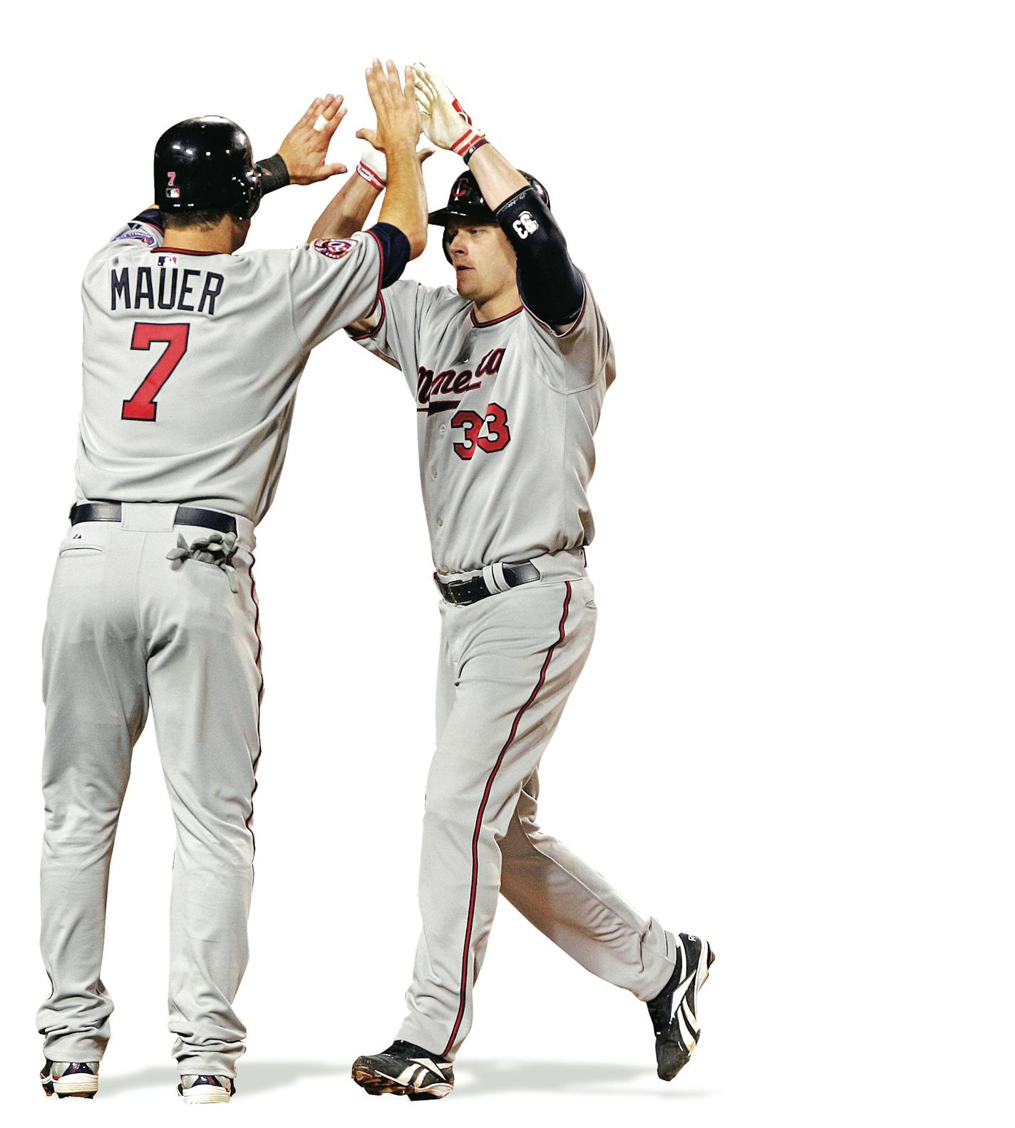 Minnesota Twins' Justin Morneau, center, is greeted by teammate Joe Mauer after hitting a two-run home run in the fourth inning of a baseball game against the Los Angeles Angels in Anaheim, Calif., Wednesday, April 7, 2010. Angels catcher Mike Napoli, right, looks on. (AP Photo/Jae C. Hong)