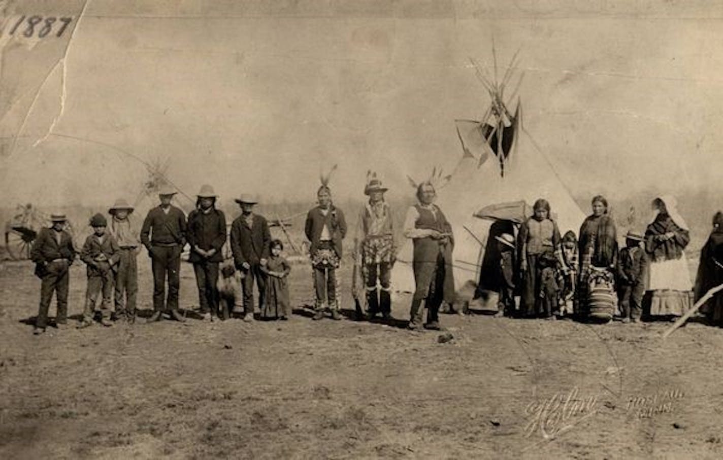 The families of Chiefs Mickinock and Cobenais posed in 1887 at their main village on Roseau Lake, which was drained for farming in the early 1900s. Mickinock is in the center, holding a rifle at his side, with Cobenais on his left in front of the tepee.