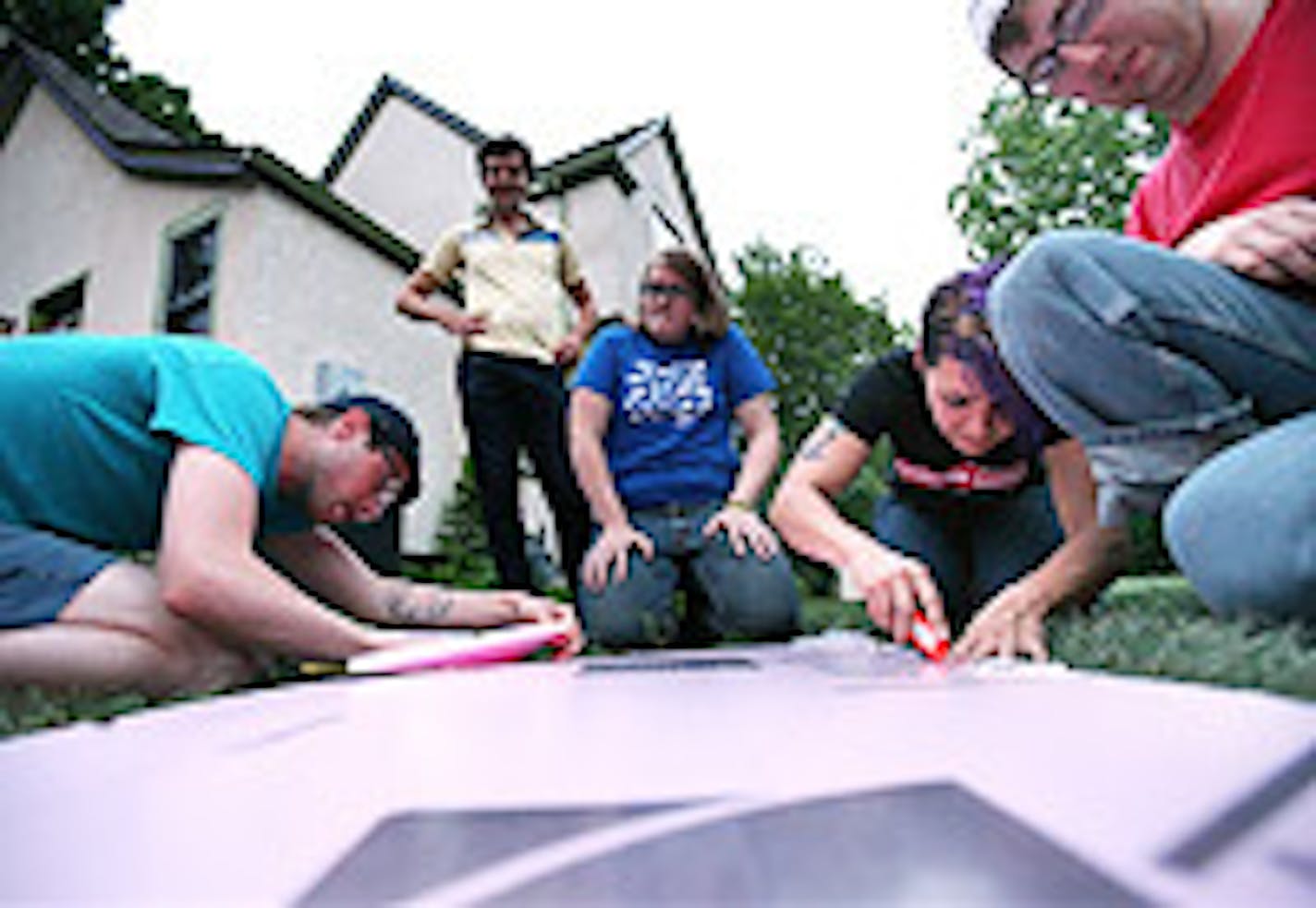 Dan Luedtke, left, and Breeana Blalock of the Revolting Queers collective worked on the group's Pride parade float as other members of the group watched.