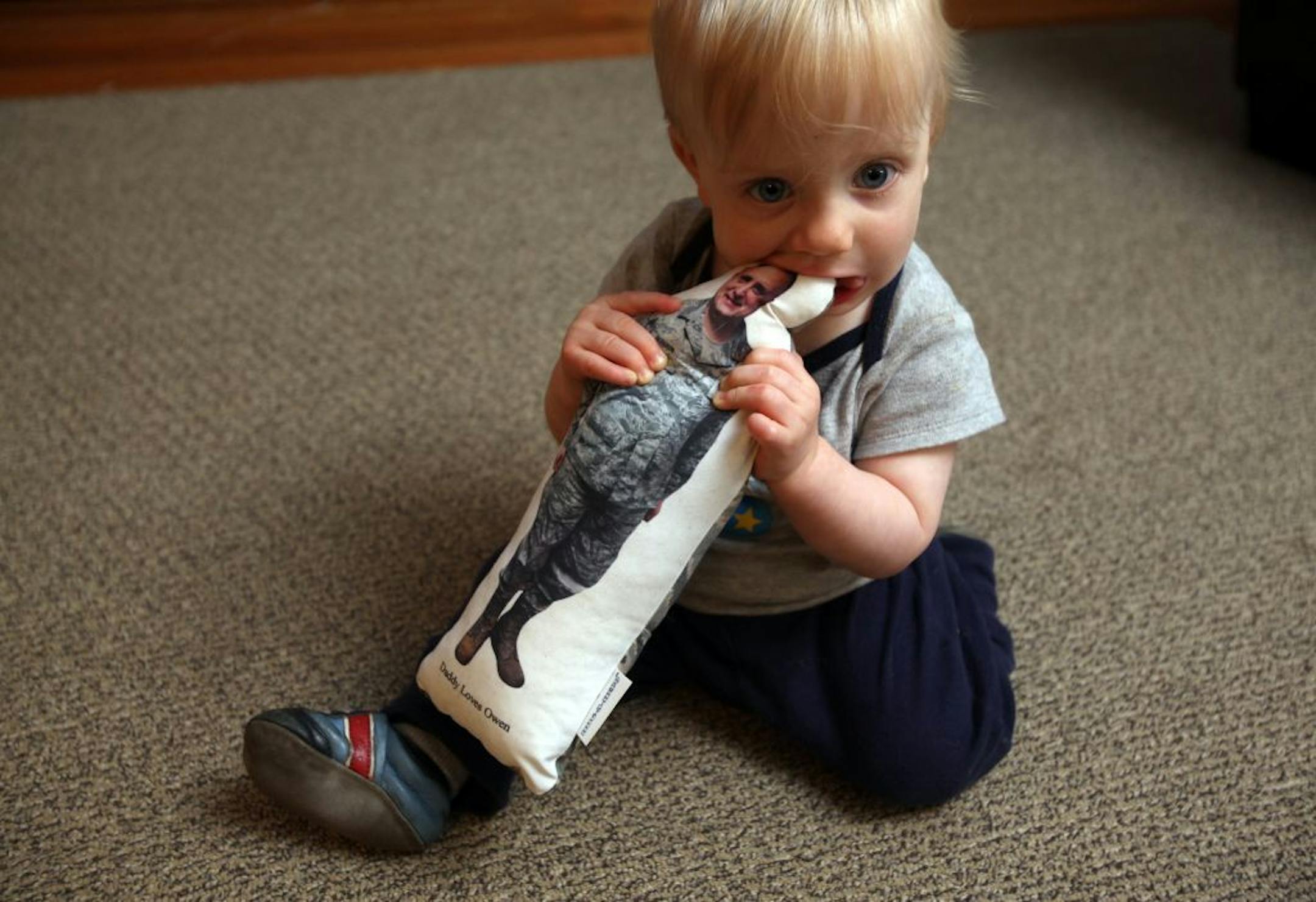 Eleven-month old Owen Bergson chewed on a doll of his dad, Brian Bergson, who is serving in Afghanistan. "The consequences of war are equally shared between husband and wife," Bergson said. "I think it has been harder on her than me and I will have to live with that."