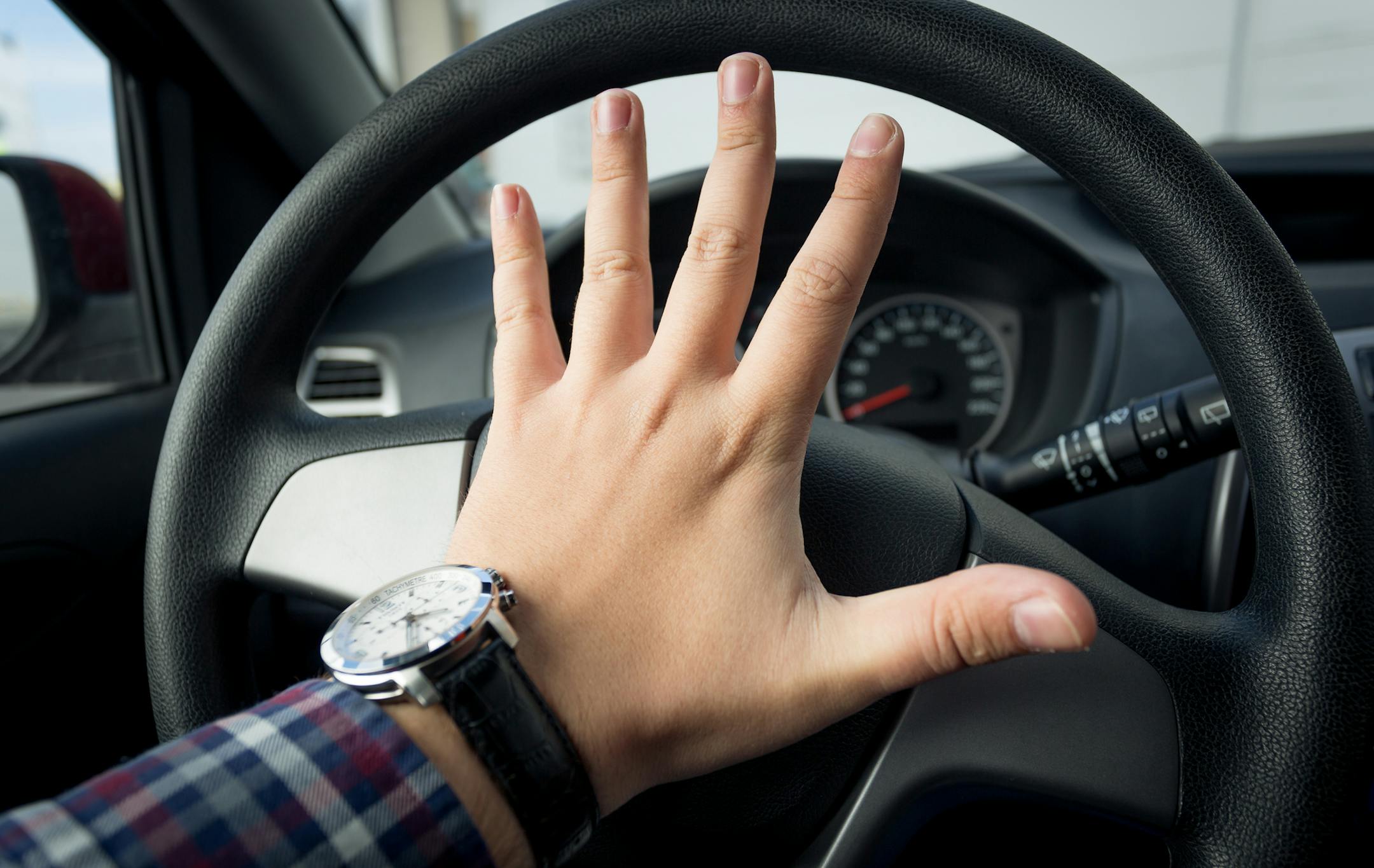 Closeup photo of angry driver honking in traffic istock