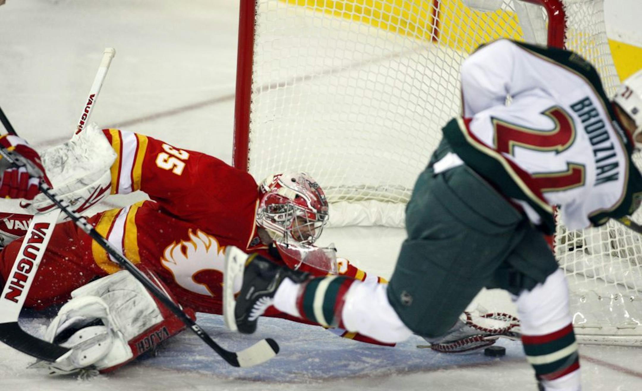 Minnesota Wild's Kyle Brodziak has his shot stopped by Flames goalie Joey MacDonald.