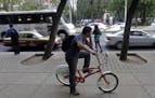 A man speaks on the phone while riding on an "Ecobici" bicycle in Mexico City, Wednesday April 21, 2010. This spring the city government launched "Eco