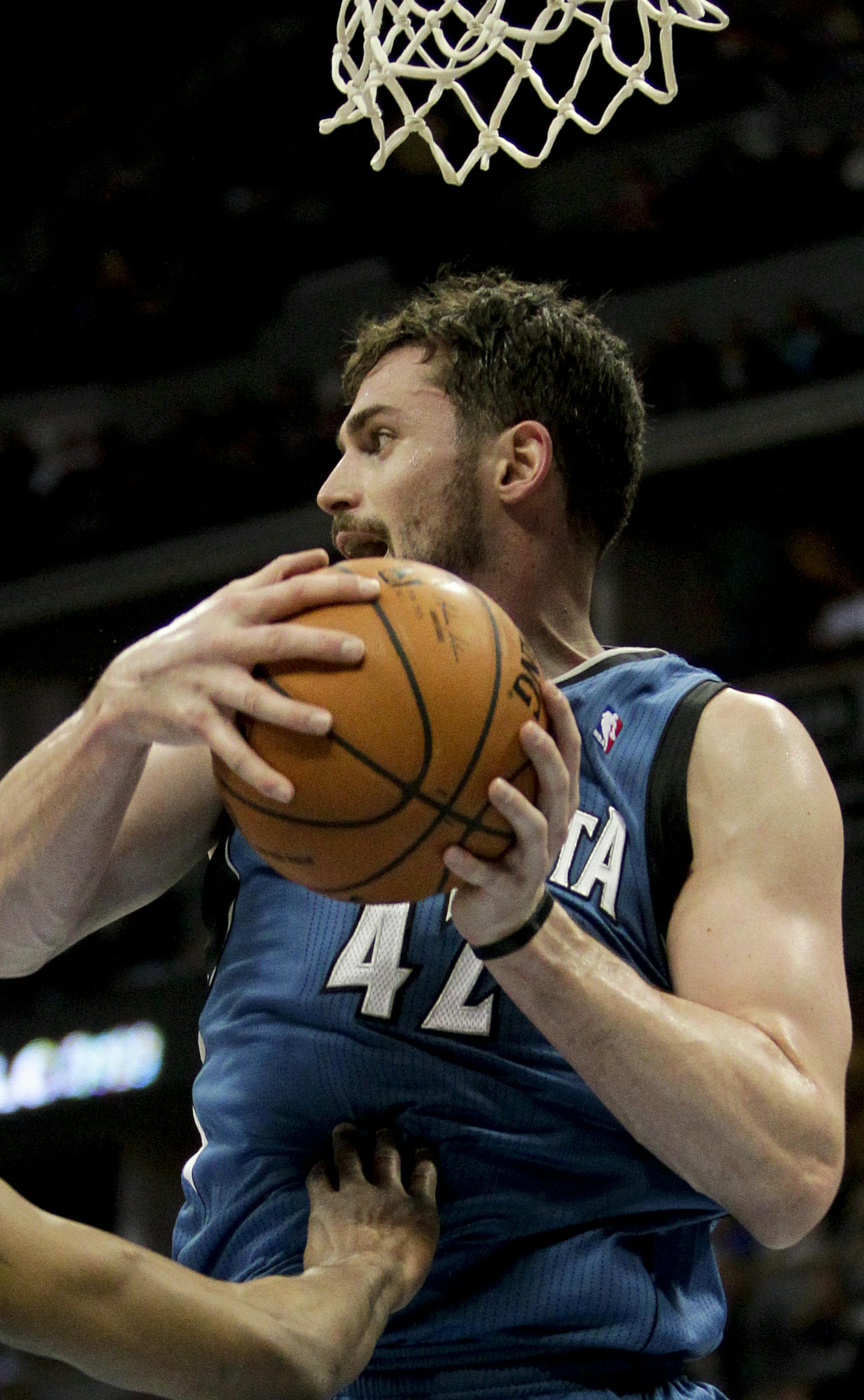 Minnesota Timberwolves' Kevin Love (42) grabs a rebound against the Denver Nuggets during the first quarter of an NBA basketball game Monday, March 3, 2014, in Denver. (AP Photo/Barry Gutierrez)