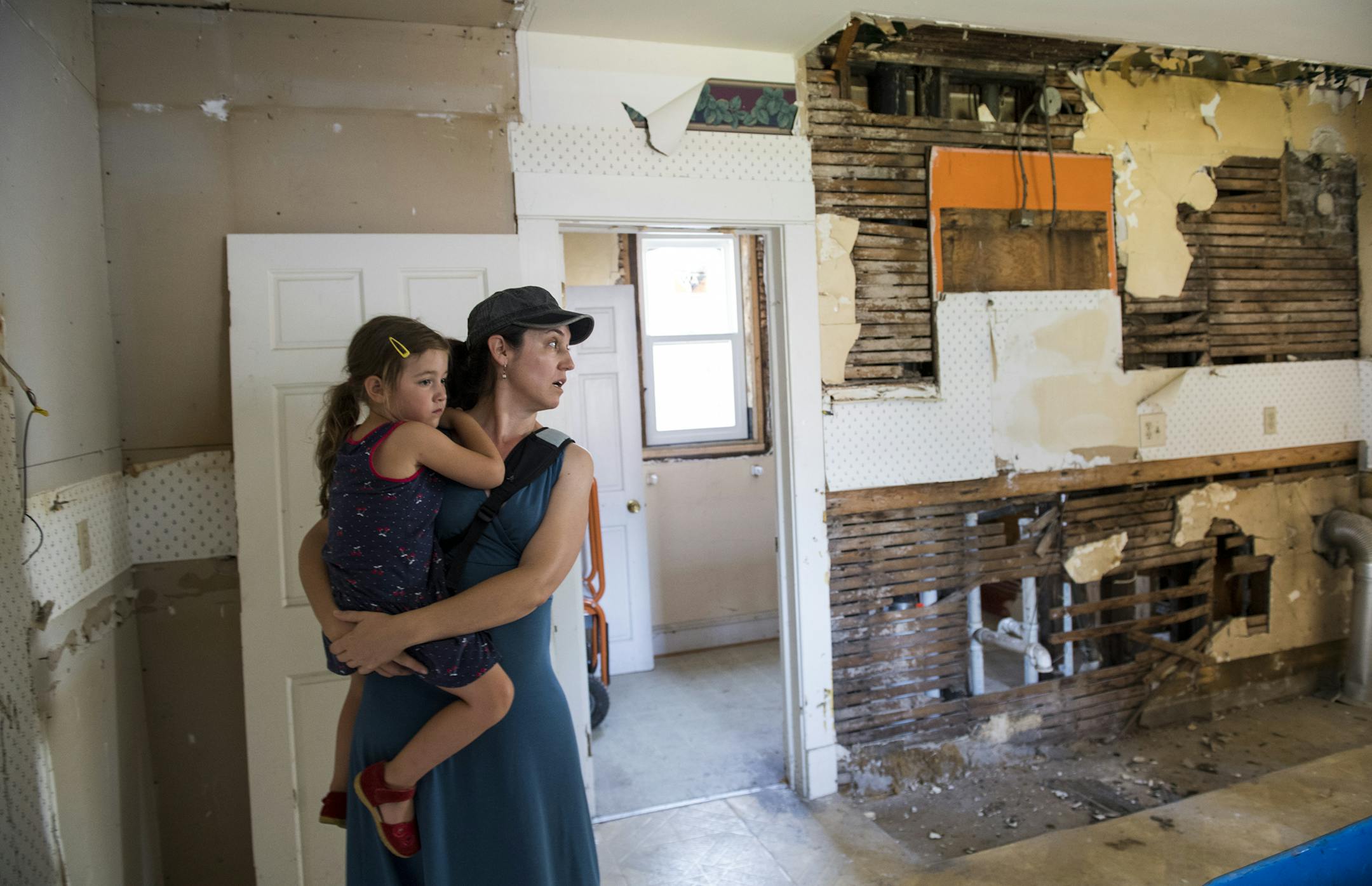 Bree St. Peters walked around the kitchen of the home she's refurbishing with her daughter Zea Andriolo, 4, in her arms on Friday. ] Isaac Hale ï isaac.hale@startribune.com Bree St. Peters walked around the tax-forfeited home on North 3rd Street she's refurbishing and where she'll soon be living. A county auction sold many properties such as this with the stipulation that they had to be repaired in one year, which is up on July 30th.