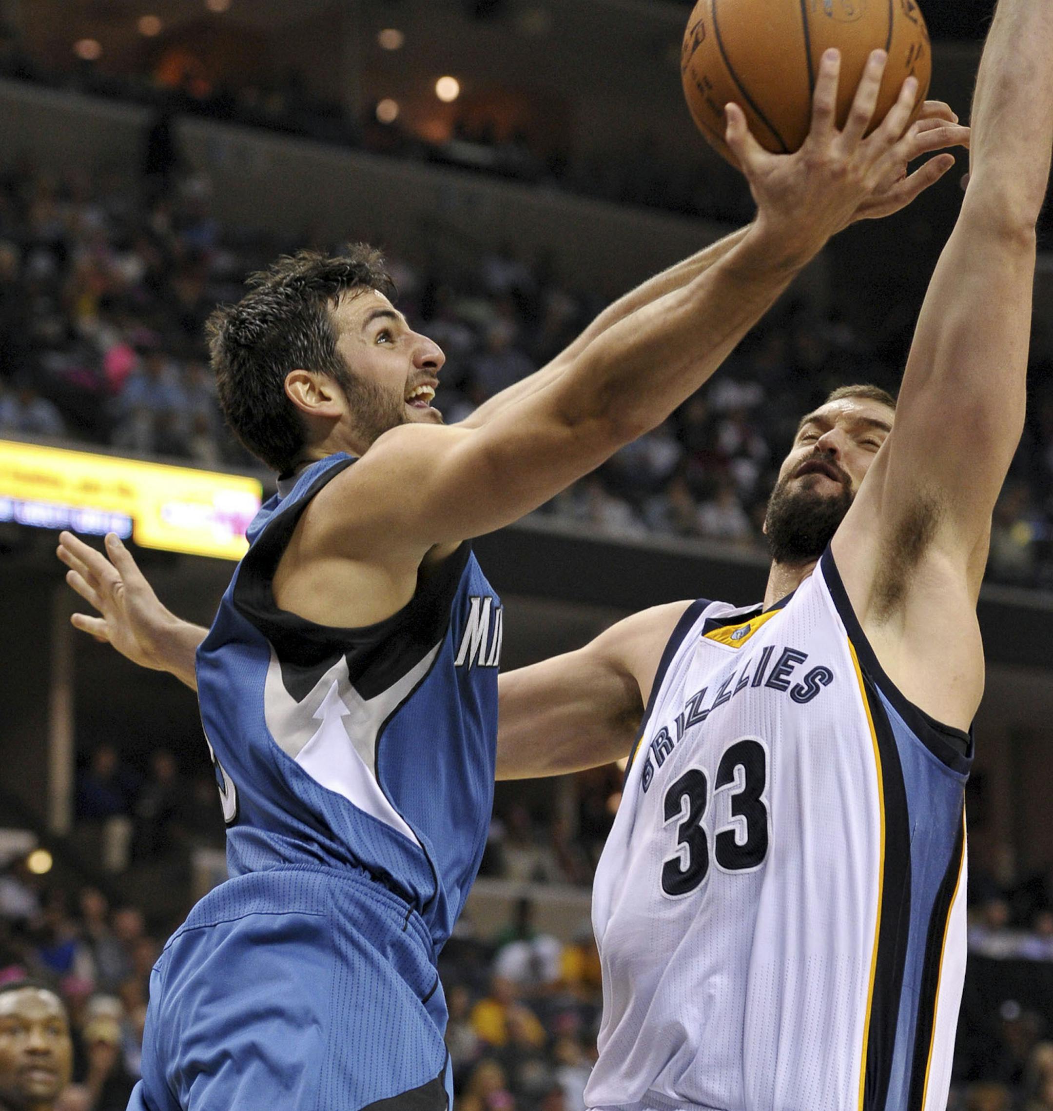 Minnesota Timberwolves guard Ricky Rubio, left, shoots against Memphis Grizzlies center Marc Gasol (33) in the second half of an NBA basketball game Wednesday, Oct. 29, 2014, in Memphis, Tenn. (AP Photo/Brandon Dill)