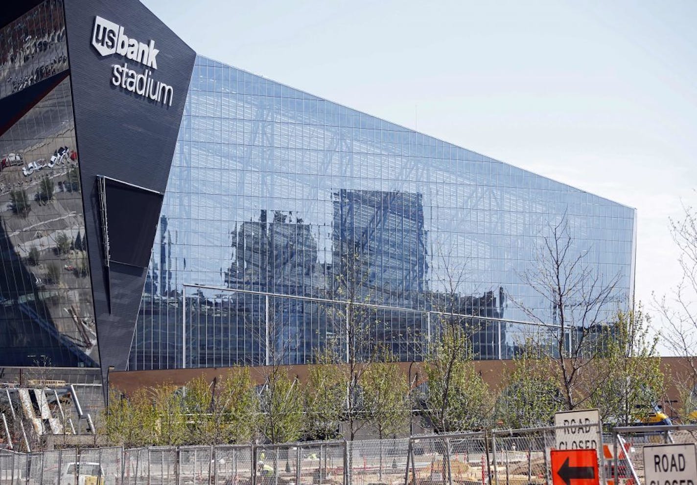 Downtown Minneapolis is reflected and newly planted trees line the park which adjoins the U.S. Bank Stadium, the new stadium for the home to the Minnesota Vikings NFL football team, Wednesday, May 5, 2016, in Minneapolis, as work continues toward the completion of the $1.2 billion stadium.