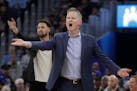 Golden State Warriors head coach Steve Kerr, foreground, and injured guard Klay Thompson react to an official's call during the first half of an NBA b