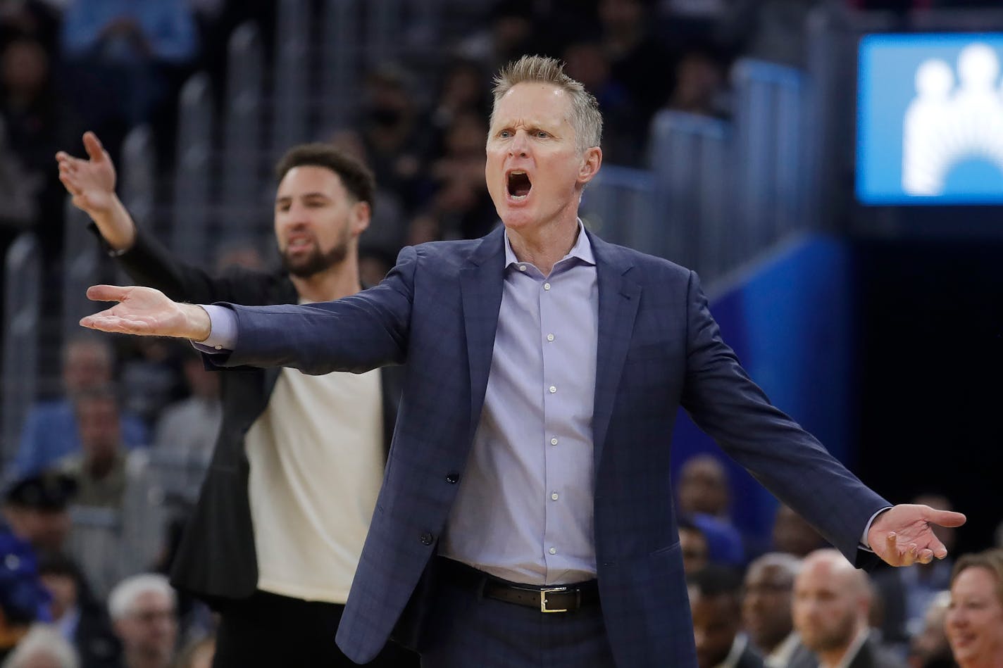 Golden State Warriors head coach Steve Kerr, foreground, and injured guard Klay Thompson react to an official's call during the first half of an NBA basketball game against the Dallas Mavericks in San Francisco, Saturday, Dec. 28, 2019. (AP Photo/Jeff Chiu)