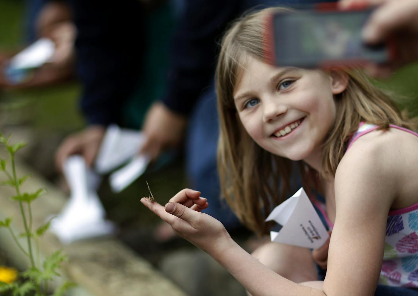 Adalyn Schoen, 7, posed for a photo while she held a butterfly before releasing it at Lawshe Park in South St. Paul on Monday. ] CARLOS GONZALEZ cgonzalez@startribune.com June 3, 2013, South St. Paul, Minn., South St. Paul Girl Scouts are capping a service project by planting a butterfly garden in a city park and releasing scores of butterflies.