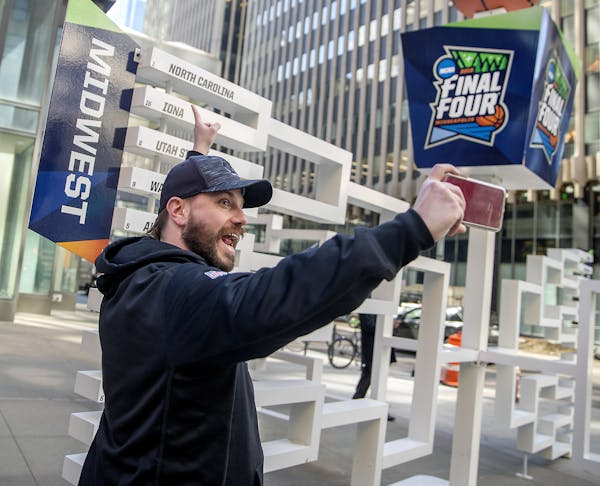 Brad Hardin took a selfie as he found his favorite team, North Carolina, on a 3D sculpture of the Final Four bracket on the Nicollet Mall