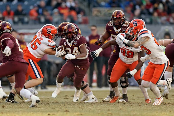 Gophers running back Mohamed Ibrahim (24) ran past Syracuse defensive back Justin Barron (23) during the first half of Thursday’s Pinstripe Bowl.