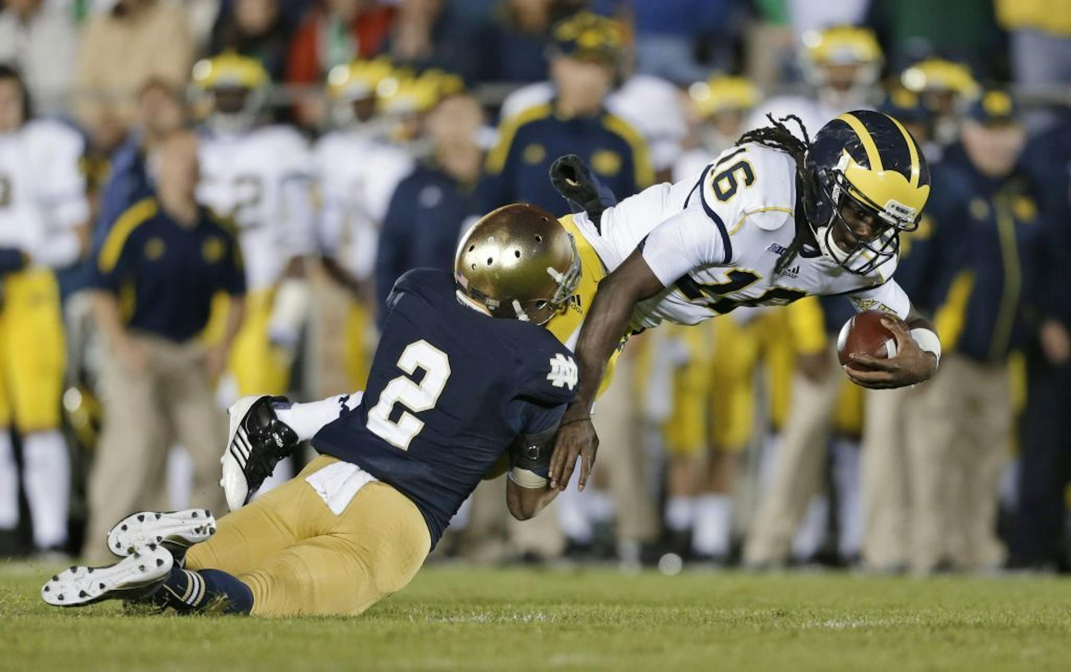 Michigan's Denard Robinson (16) is tackled by Notre Dame's Bennett Jackson (2) during the second half of an NCAA college football game Saturday, Sept. 22, 2012, in South Bend, Ind. Notre Dame defeated Michigan 13-6.