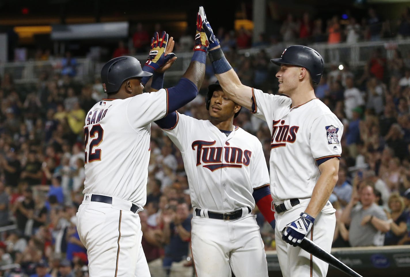 Miguel Sano, left, celebrates his two-run home run with Jorge Polanco, center, and Max Kepler in the eighth inning Tuesday.