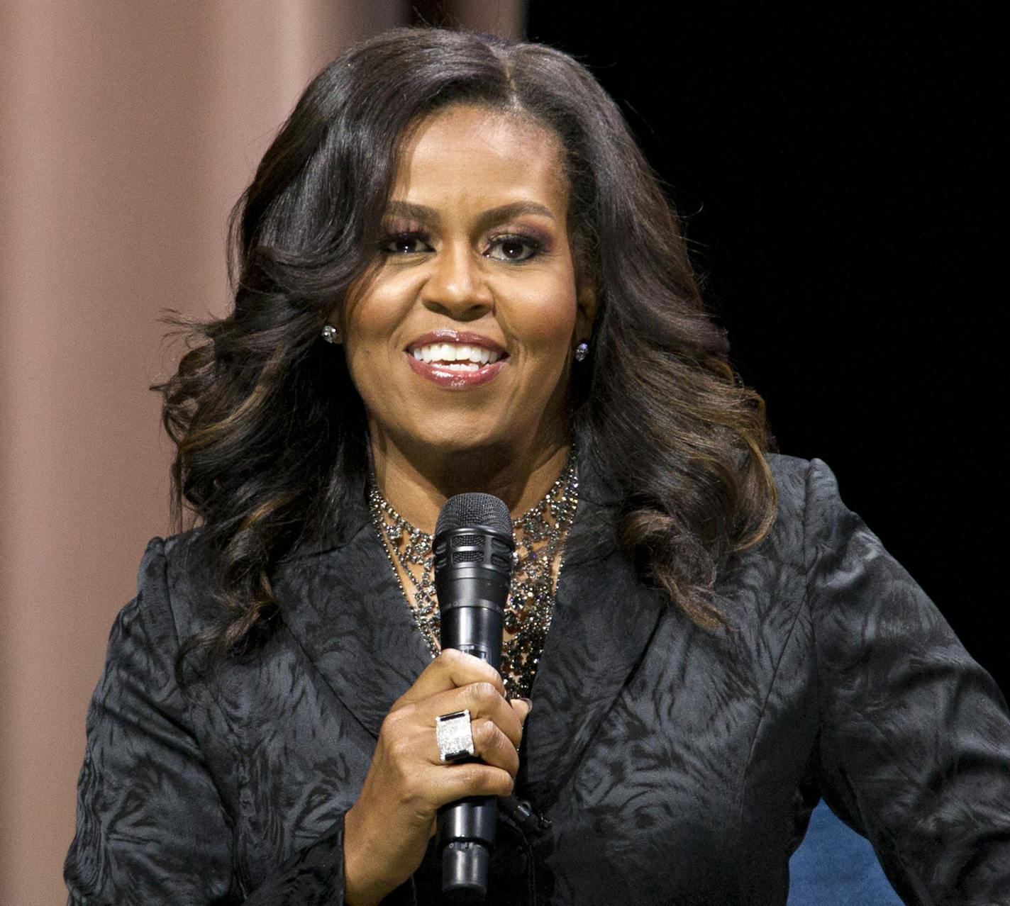 Former first lady Michelle Obama speaks to the audience during a stop on her book tour for "Becoming," in Washington on Sunday, Nov. 25, 2018. (AP Photo/Jose Luis Magana)