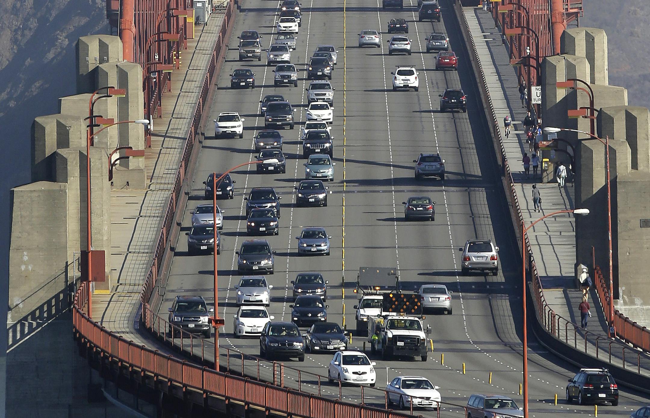 FILE - In this Thursday, Sept. 19, 2013 file photo, Golden Gate Bridge workers shift traffic lanes during the end of the morning commute in San Francisco. The Golden Gate Bridge will close to vehicles for 52 hours starting early Saturday morning, Jan. 10, 2014 to install a steel and concrete moveable median barrier that will help make the iconic bridge safer to commuters. (AP Photo/Eric Risberg)