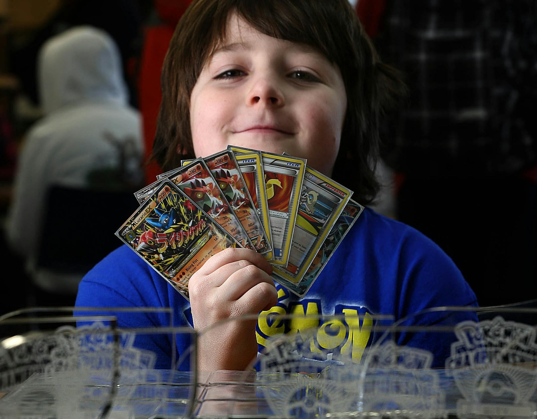 Malachi Fox, 9, compete in a small regional Pokemon card tournament at a comic book store.