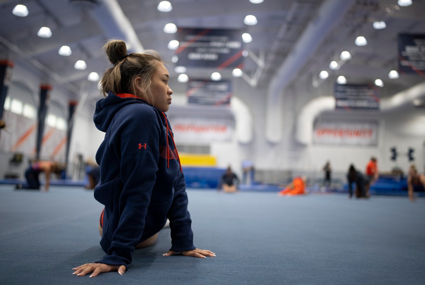 Suni Lee stretches with her Auburn Tigers teammates at the beginning of a workout Friday, Dec. 17, 2021 at the McWhorter Center in Auburn. St. Paul native Suni Lee, a triple medalist in gymnastics at the 2021Tokyo Olympic games and now an Auburn University freshman gymnast, worked out with her teammates at the McWhorter Center. ] JEFF WHEELER • Jeff.Wheeler@startribune.com ORG XMIT: MIN2112192041370138