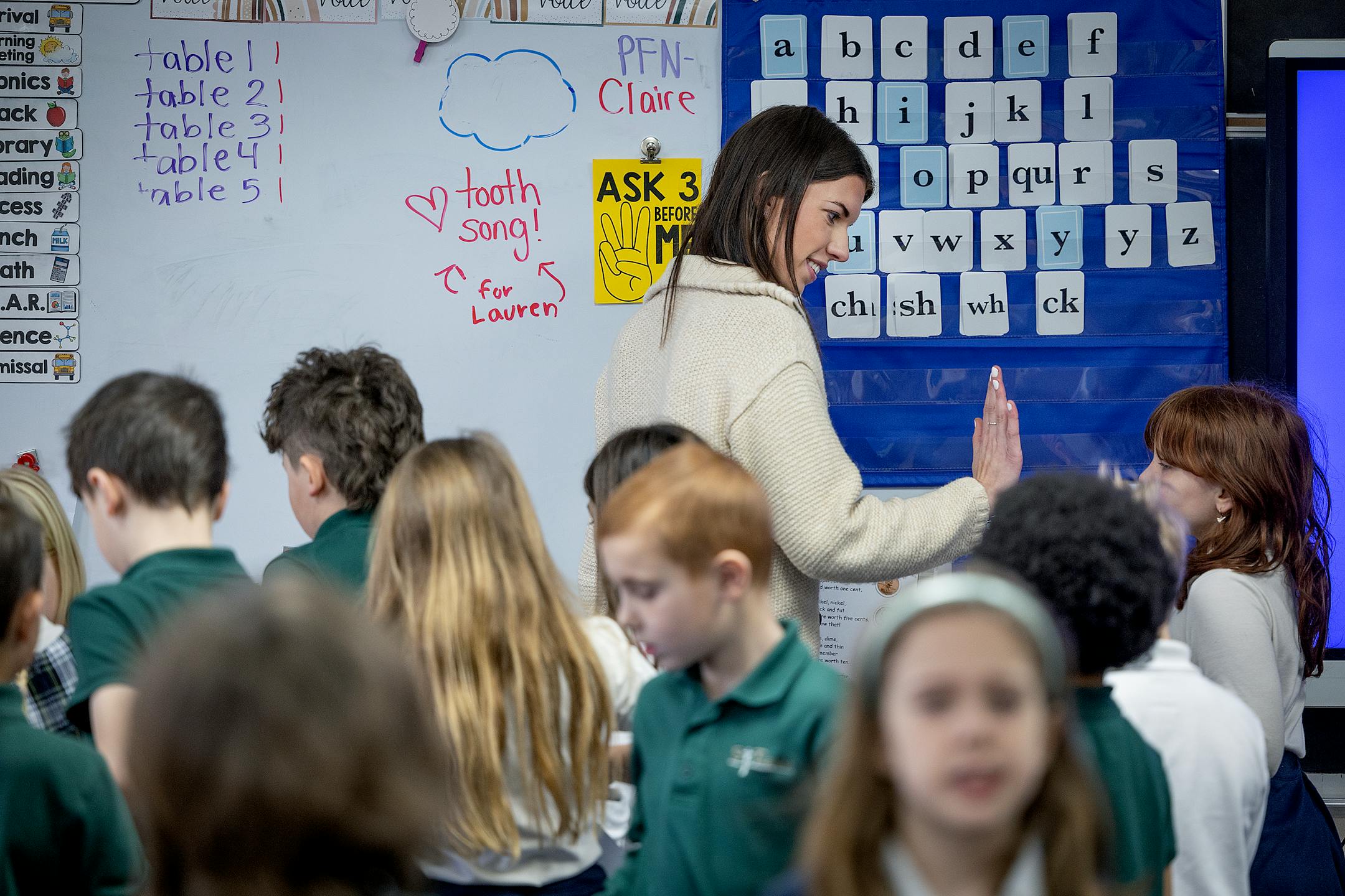 Matty McGarvey gives a high-five to a student between assignments in her second grade class.