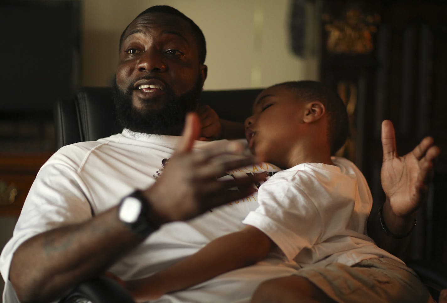 Tyrone Carter with his son, Tyree, snoozing in his lap, during an interview in in their St. Louis Park home. ] JEFF WHEELER &#x201a;&#xc4;&#xa2; jeff.wheeler@startribune.com Former Gopher standout and NFL player Tyrone Carter has moved back to the Twin Cities to be closer to his wife April's family and to launch his own football training camp. They were photographed in their St. Louis Park home Wednesday, June 4, 2014.