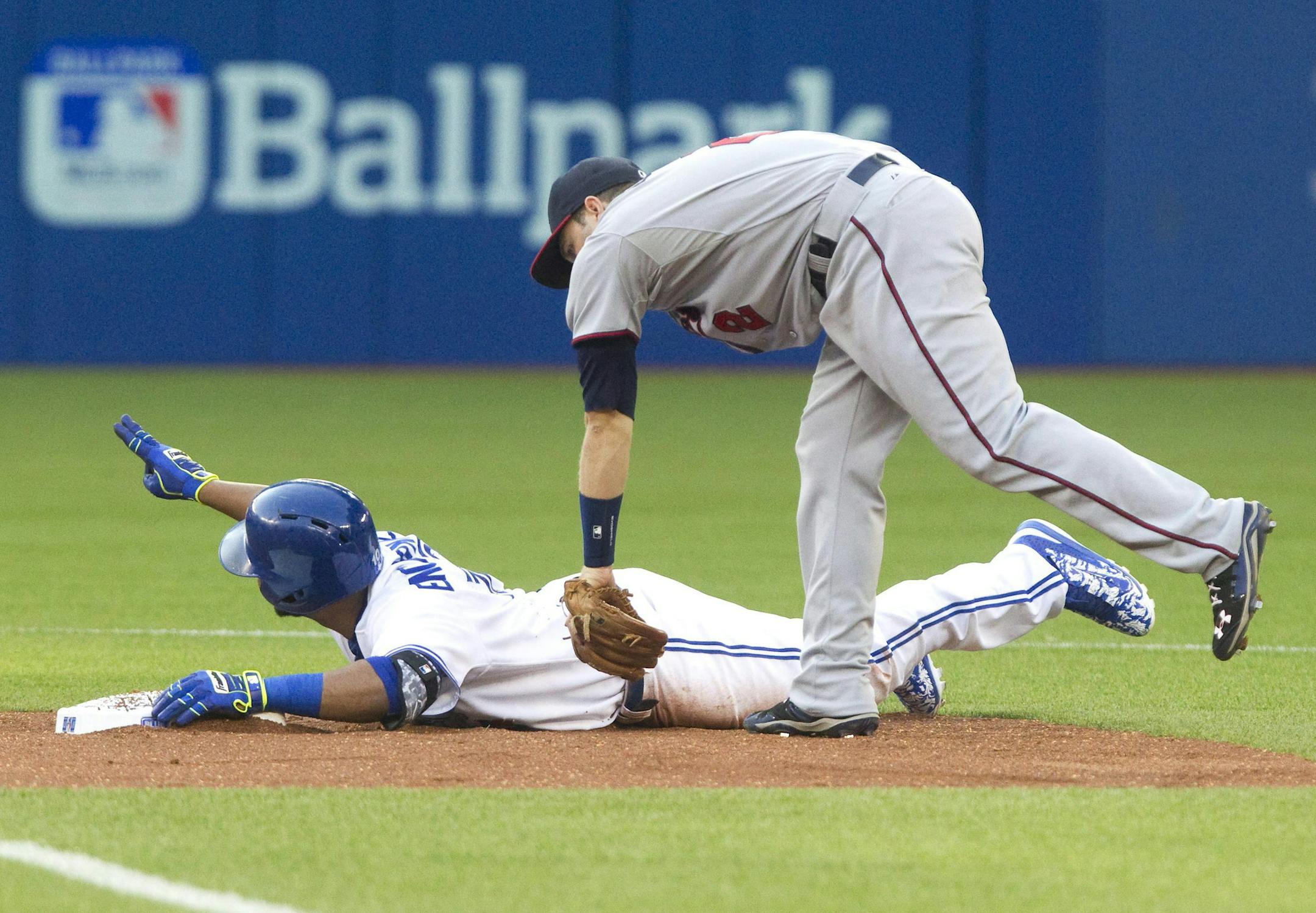Toronto Blue Jays' Edwin Encarnacion is safe on a double as Minnesota Twins' Brian Dosier comes down late with the tag during the first inning of a baseball game Thursday, Aug. 6, 2015, in Toronto. (Fred Thornhill/The Canadian Press via AP)