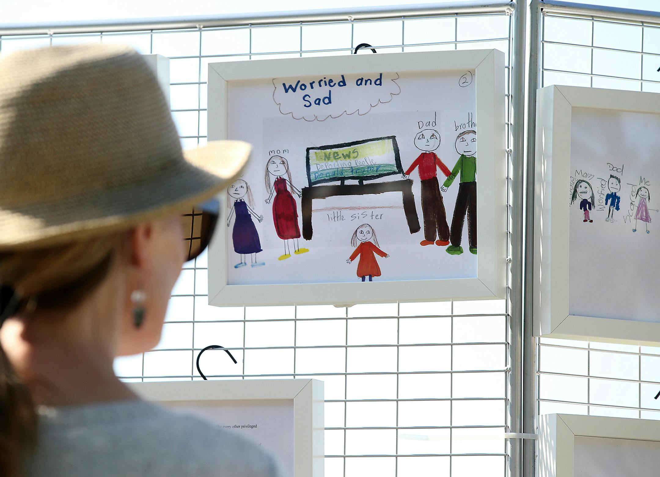 The City of Bloomington debuted the Children of Immigrants Art Exhibit at the Bloomington Farmers Market on Saturday, Sept. 8, 2018, in Bloomington, MN. Here, Heidi Voss, a pediatric nurse at Children's Hospital in Minneapolis, looks over artwork by the children. "It does hurt," Voss said of looking at the art which Voss said was dominated by the themes of fear and sadness.] DAVID JOLES ï david.joles@startribune.com (EDITOR'S NOTE: FAMILY DID NOT WANT LAST NAME USED) Latino families in Bloo
