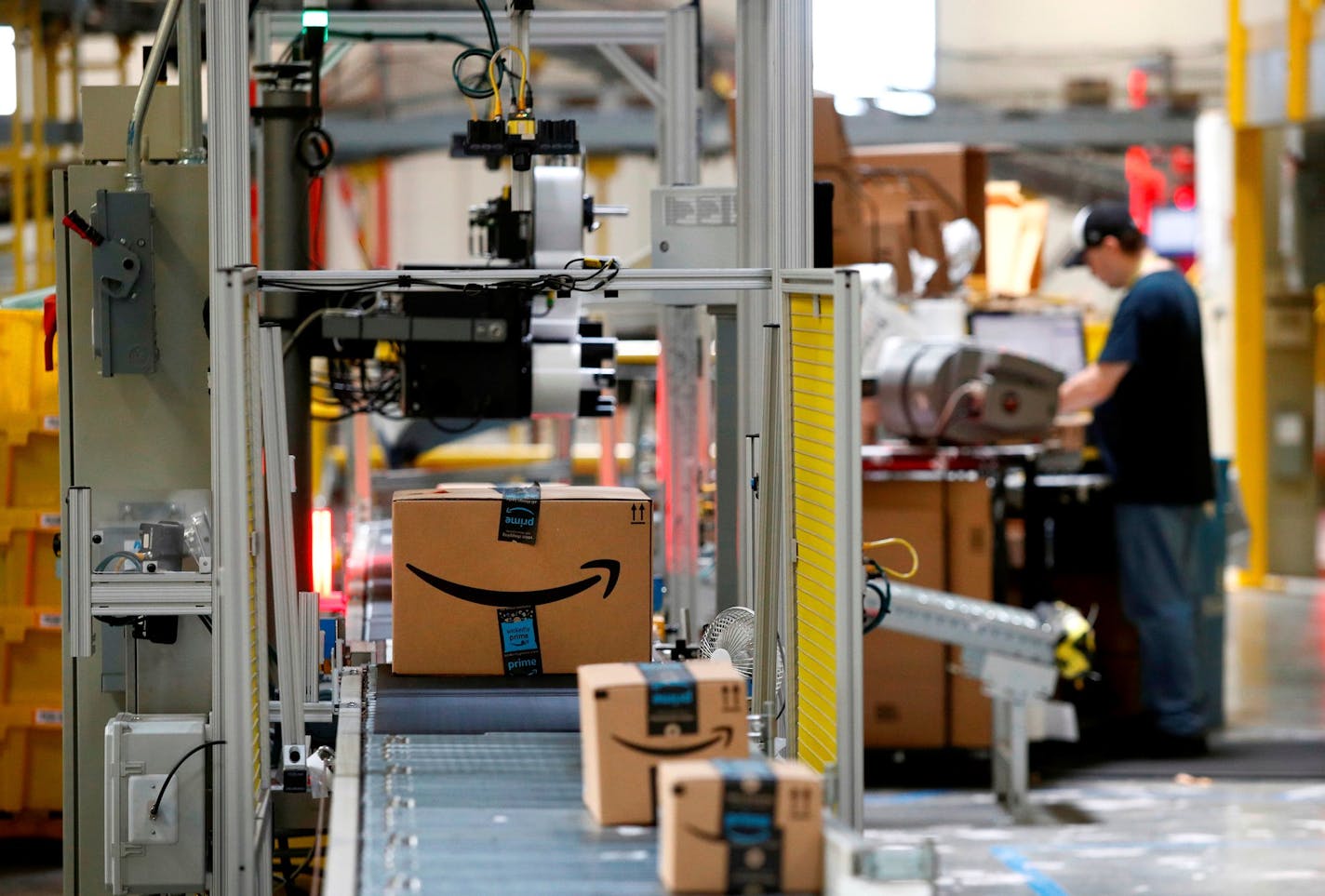 FILE - In this Aug. 3, 2017, file photo, packages pass through a scanner at an Amazon fulfillment center in Baltimore. A task force will study the U.S. Postal Service under an executive order from President Donald Trump, who has spent weeks criticizing online retailer Amazon and accused it of not paying enough in shipping costs. (AP Photo/Patrick Semansky, File) ORG XMIT: NYBZ522