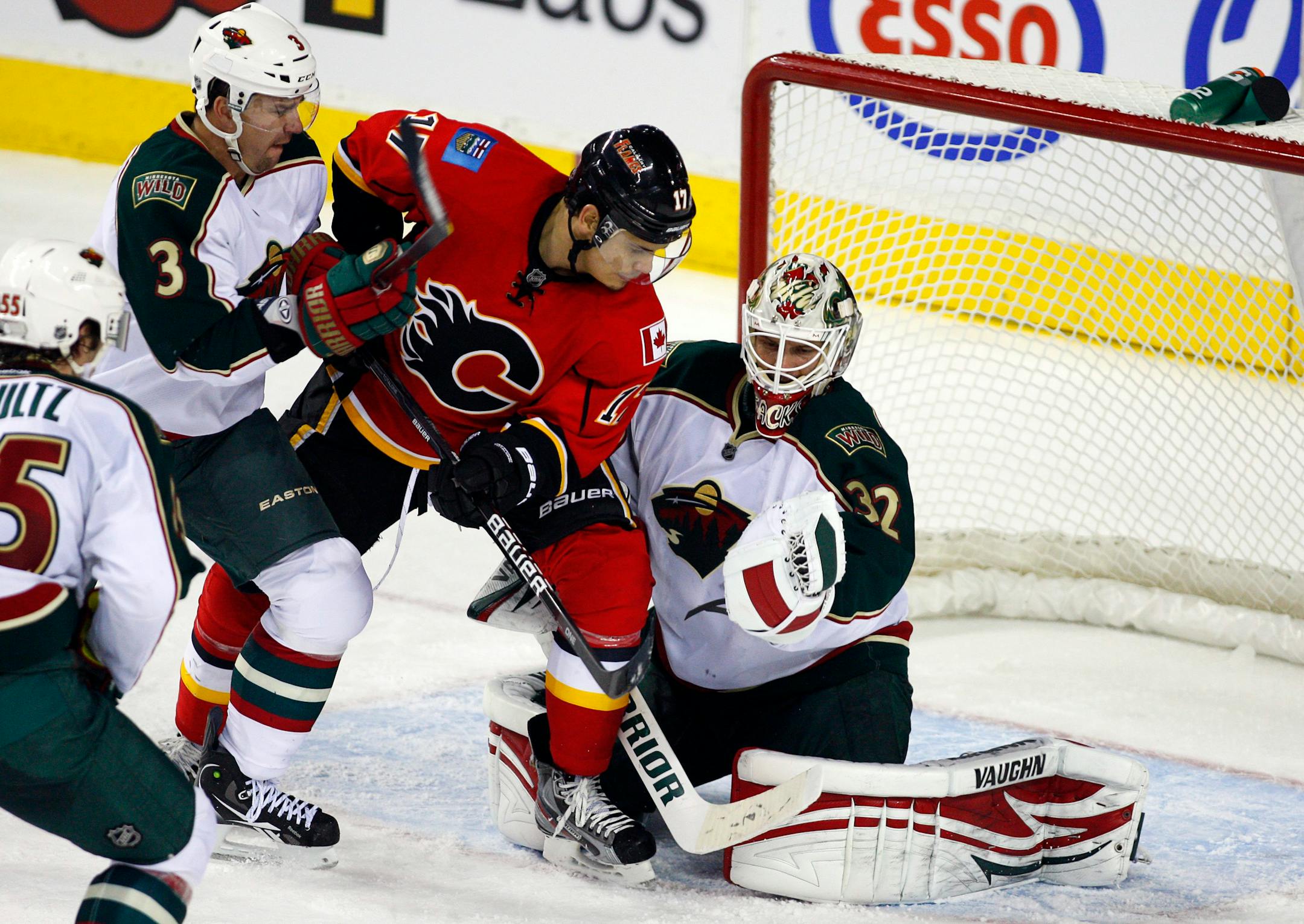 Wild goalie Niklas Backstrom grabbed the puck as teammate Marek Zidlicky, left, checked Calgary's Rene Bourque during second period Tuesday. Backstrom made 41 saves in the Wild's 3-0 victory.