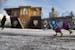 A dog clad against cold runs in front of the Upside Down House at the All-Russia Exhibiton Center in in Moscow, Russia, Friday, Jan. 17, 2014. Its cre